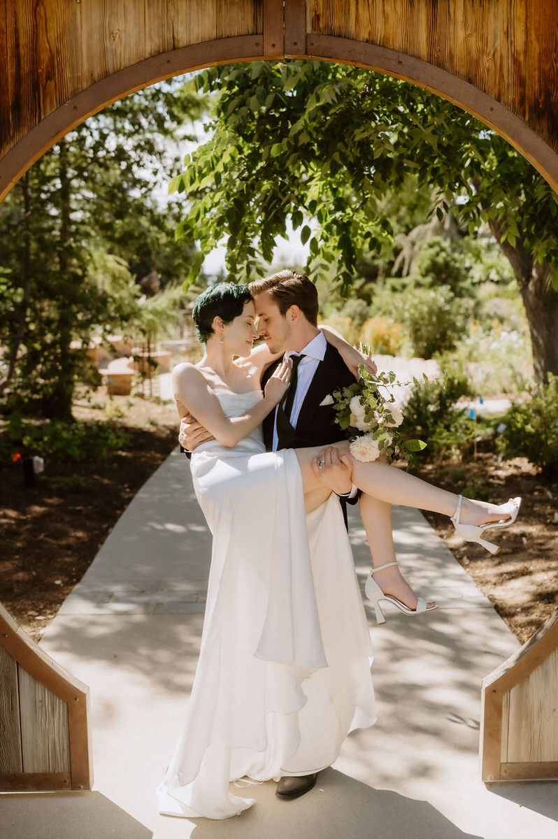 A person holding their partner in a wedding dress during their Denver botanic gardens wedding