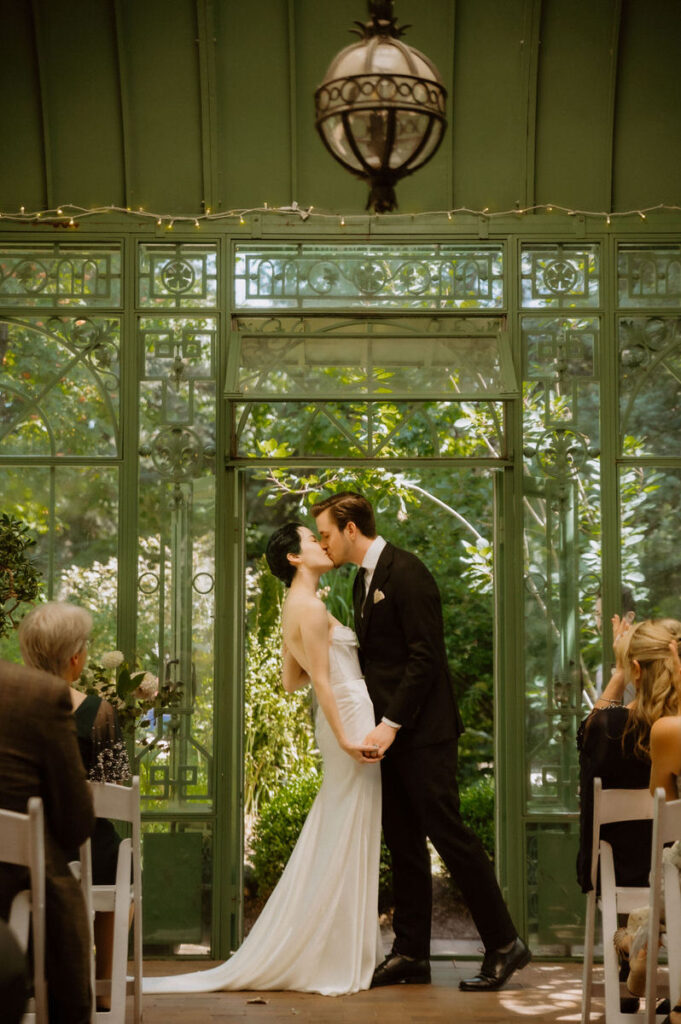 A wedding couple during their first kiss 