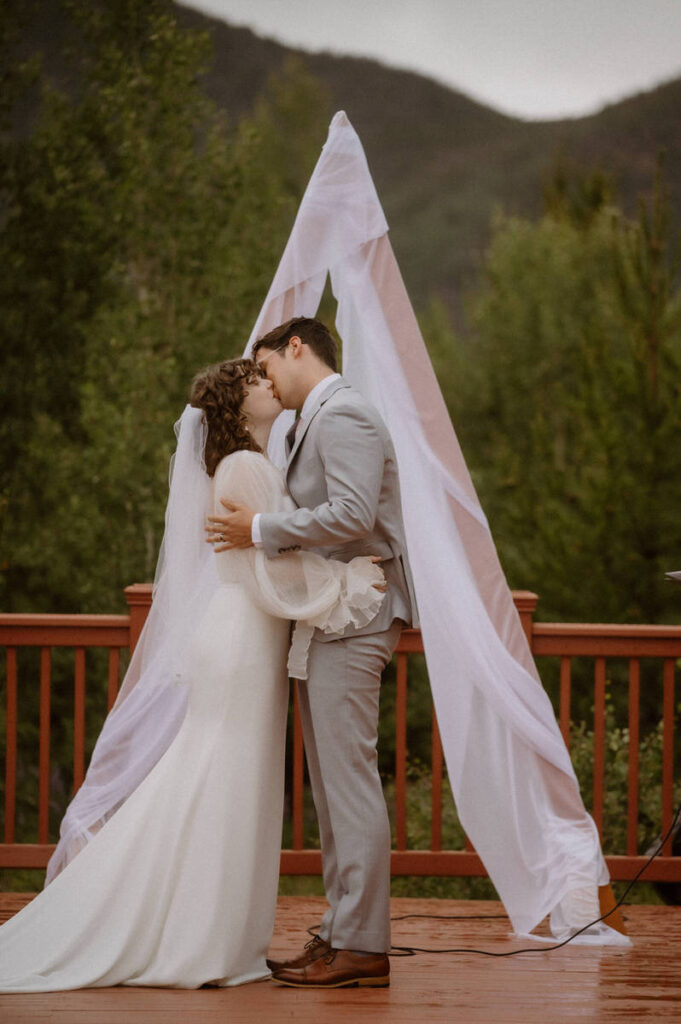 A couple during their first kiss during their mountain elopement 