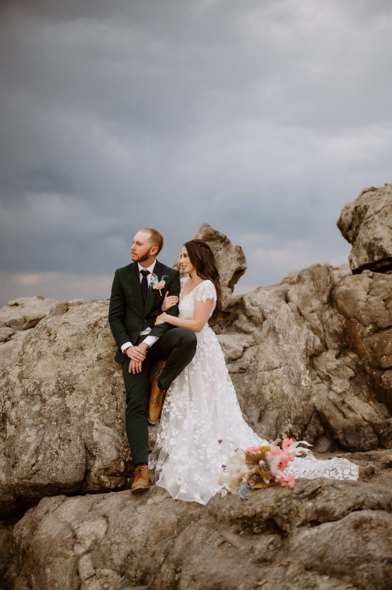 a couple having their elopement at lost gulch overlook in colorado the woman is wearing a white wedding dress the man is wearing a black suit 