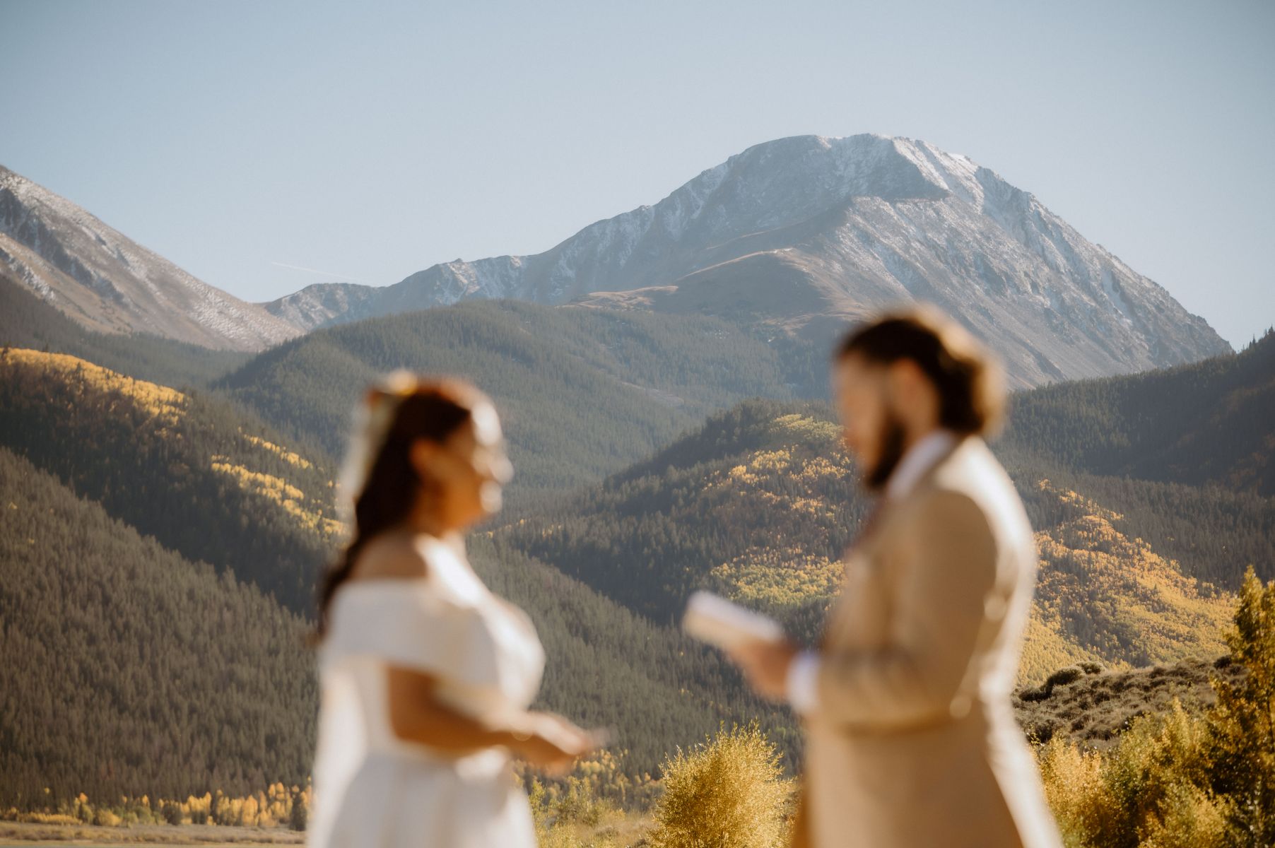 a man reading vows to his partner next to a mountain for their elopement ceremony